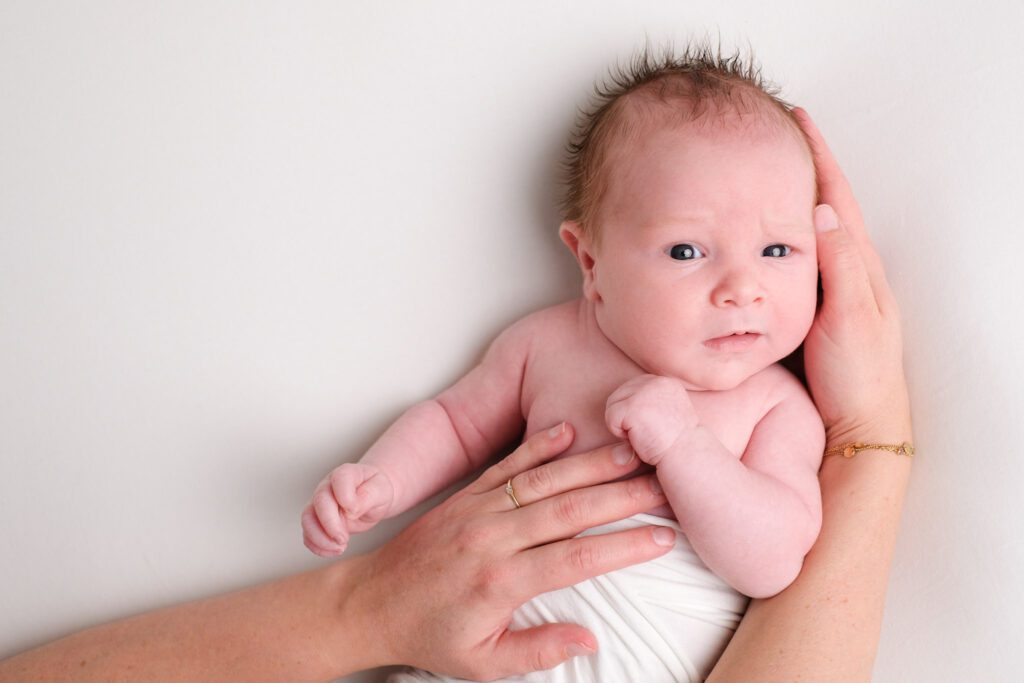 Babyfotografie met handen van moeder